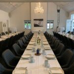 Mødelokale i Odense med tre langborde dækket op til konference frokost.